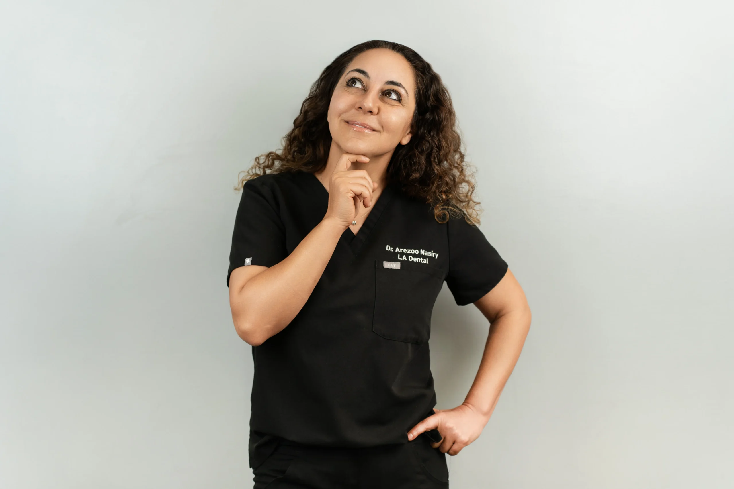 Dr. Arezoo Nasiry from LA Dental in Los Angeles thoughtfully smiling, featured on the smile makeover page.